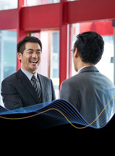 Two businessmen smiling and shaking hands